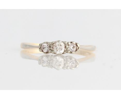 A three stone ring, centrally claw set with a round cut diamond, measuring approx. 0.15ct, flanked to either side with a colo