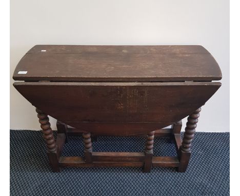 An oak early 20th century drop leaf table with bobbin turned legs.