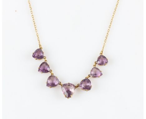 An amethyst fringe necklet, set with seven triangular cut amethysts suspended from a belcher link chain, yellow metal unmarke