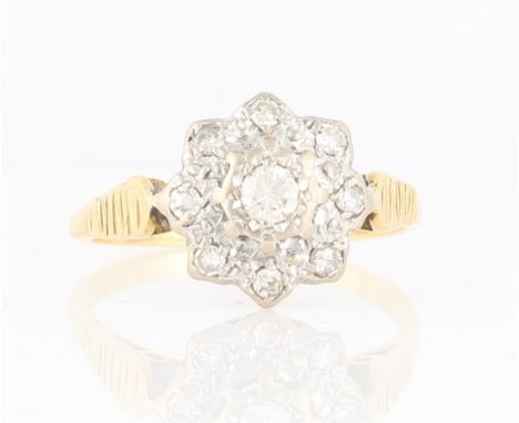 A diamond set flower design ring, set with a central round brilliant cut diamond, measuring approx. 0.15ct, surrounded by a b