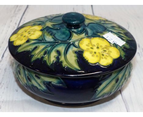A circular Moorcroft trinket jar decorated with yellow flowers and leaves on blue ground, impressed, 5" (chip to inner rim of