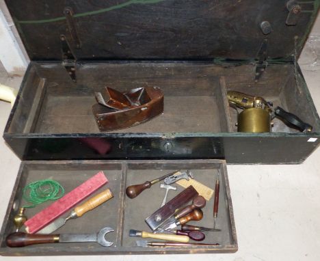 A tool chest containing a brass blow lamp and vintage tools
