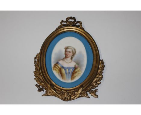 A Sevres oval porcelain plaque portrait of a young woman, contained in a gilt ribbon decorated frame 