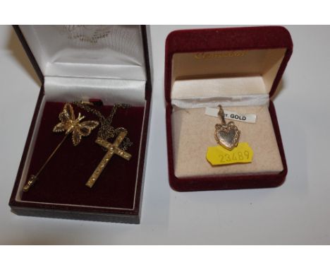 A 9ct gold cross on chain; a 9ct gold heart shaped locket and a stick pin 