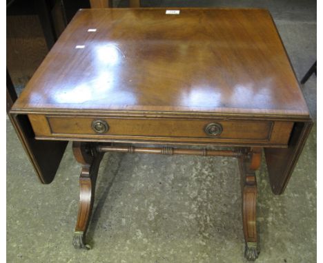 Reproduction walnut sofa table on brass paws and casters.(B.P. 24% incl. VAT)