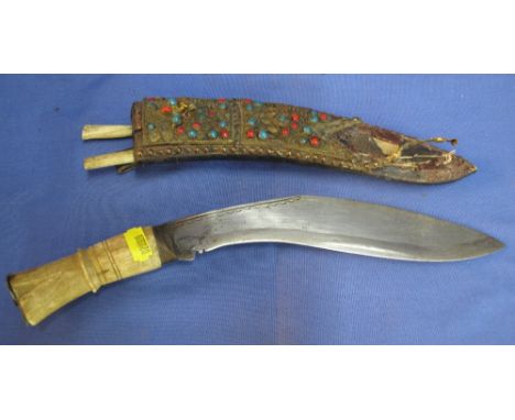 Small bone handled Nepalese Kukri with miniature knives, the leather scabbard decorated with semi precious stones and gilt me