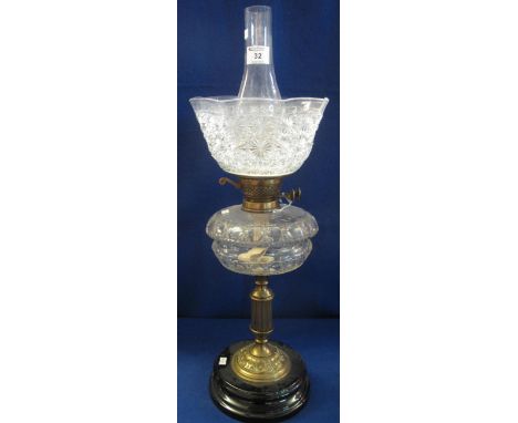 Early 20th Century brass double burner oil lamp with cut glass, clear reservoir, brass pedestal and ceramic base, having moul
