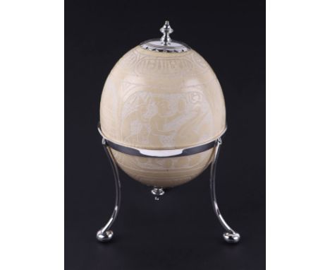 An Egyptian / Islamic silver plated mounted carved ostrich egg decorated with figures and Islamic script, on a silver plated 