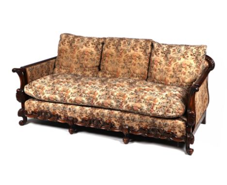 A 1920's Maple & Co. style carved walnut and upholstered 17th century inspired country house sofa with feather filled cushion