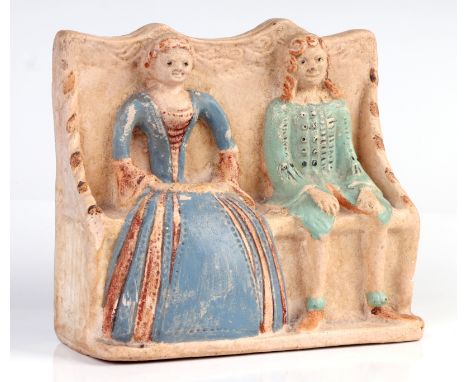 A flat back pottery group depicting an Elizabethan couple seated on a settle, possibly Compton Pottery, 15cm high.Condition R