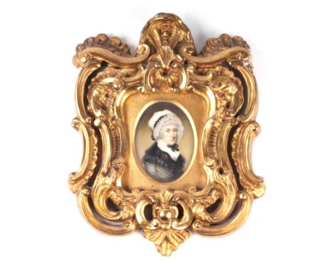 An early 19th century portrait miniature painted on ivory depicting a lady wearing a bonnet, 5 by 7cms, in an ornate gilt fra