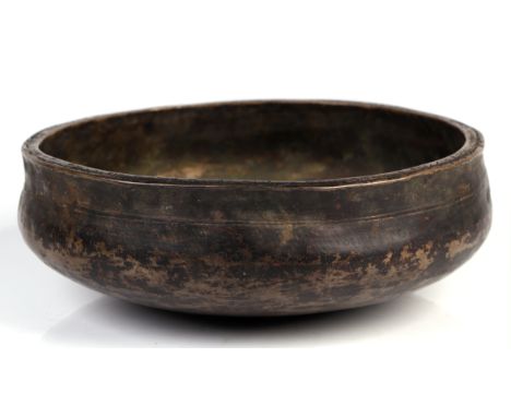 An Islamic / Persian bronze magic bowl engraved with script to the rim, outer rim and profusely engraved with a tree to the i