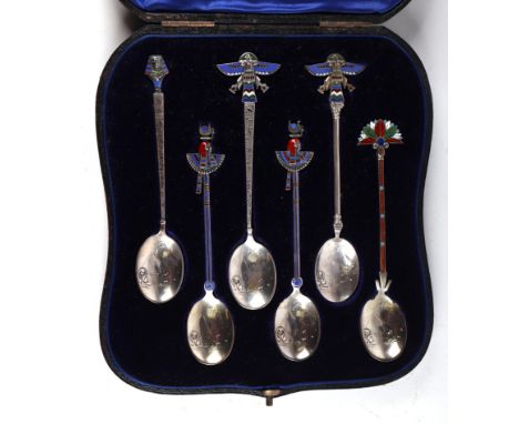 A boxed set of white metal and enamel Egyptian Revival teaspoons, the bowls decorated with a scene with a sphinx and pyramids