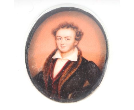 An early 19th century portrait miniature on ivory depicting a young man wearing a fur trimmed coat, glazed but unframed, 6.5 