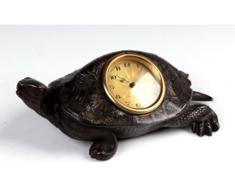 A patinated metal table clock in the form of a tortoise the gilt dial with Arabic numerals, 17cm long  