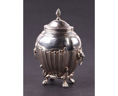 A silver tea caddy on lion paw feet, with hinged flame finial lid and lion mask ring handles, rubbed Chester marks for 1901, 
