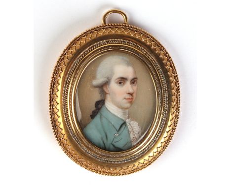 A Georgian yellow metal mounted portrait miniature pendant depicting a young gentleman wearing a blue coat, watercolour on iv