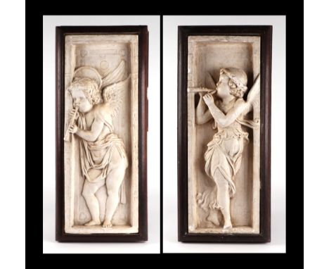 A pair of Arts & Crafts plaster relief plaques decorated with angels playing trumpets, mounted in oak frames, each overall 29