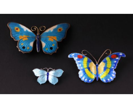 A silver and enamel butterfly brooch, 3cms wide; together with two gilt metal and enamel butterfly brooches, 6cms and 7cms wi