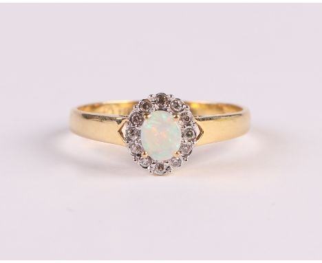 An 18ct gold ring set with a central oval opal surrounded by diamonds, approx UK size 'N', 2.3g.