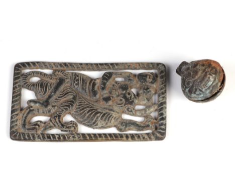 An Indo Tibetan pierced bronze plaque depicting a figure fighting a tiger, 7cm by 12cm, together with a small bronze bell, wi