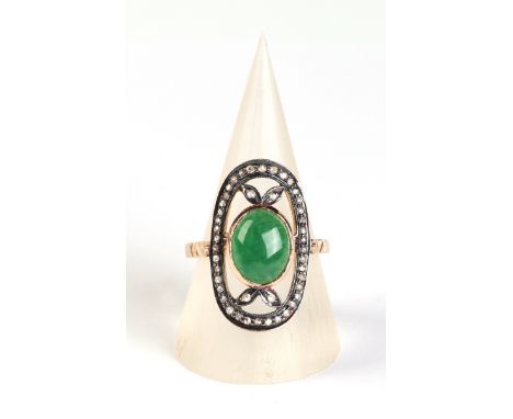A 19th century yellow metal ring set with a central jade cabochon surrounded by diamonds, approx UK size 'O', 4.8g.