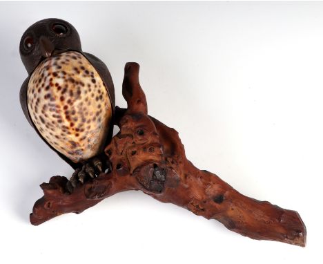 A late 19th century Cowrie shell and copper owl with glass eyes perched on a branch, possibly a wall light fitting, overall 2