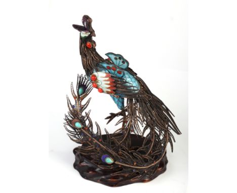 A Chinese gilt white metal and enamel figure of a peacock on a hardwood stand, overall 16cm high 