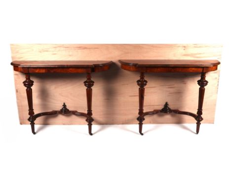 A pair of burr walnut console tables, the crossbanded shaped top above turned supports joined by a stretcher, 105cms wide (2)