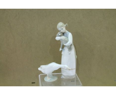 Two Lladro porcelain figures, a girl holding a lamp and a goose.