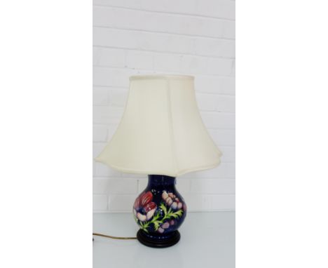 A Moorcroft cobalt blue glazed table lamp base, tube line decorated with flowers on a wooden base, height excluding light fit