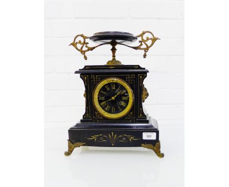 A German black slate mantle clock the circular dial with Roman numerals and flanked by lion mask ring handles, 38cm high