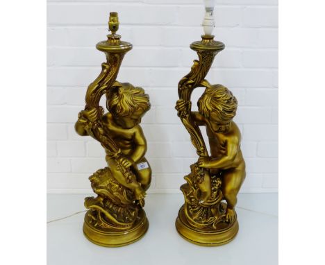 A pair of gold painted plaster Cherub figural table lamps on circular bases, 70cm high, excluding light fittings, (2)