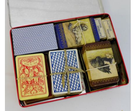 A tin containing a selection of early 20th century various playing cards 