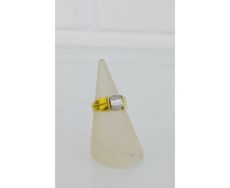 A 15 carat gold ring with a small diamond set to a white gold plaque, on a yellow gold band, UK ring size M