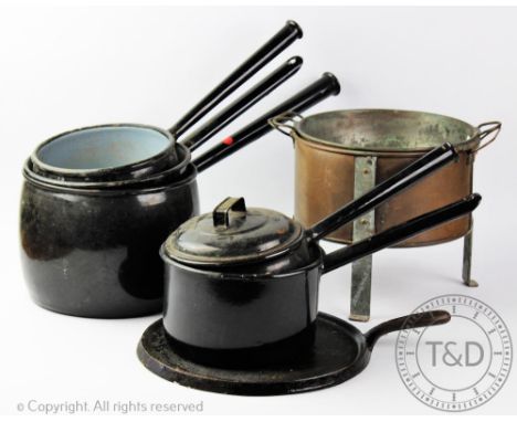 Five vintage black enamel saucepans, a two  piece copper main marie and a cast iron circular cooking plate (8)