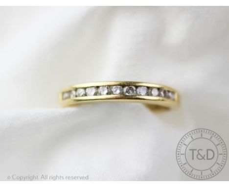 A diamond set half eternity ring, the eleven brilliant cut diamonds, all channel set in yellow metal, stamped 'Dia 033 750', 