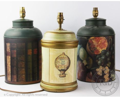 Three modern toleware type lamp bases, one decorated with antiquarian book spines, one with early hot air balloons, the other