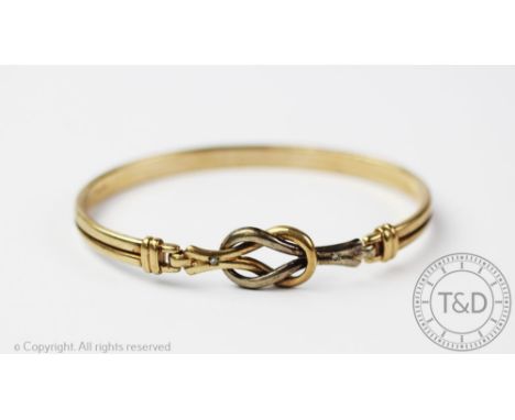 A 9ct bi-colour gold bangle, of entwined knot form, gross weight 8.4gms 
