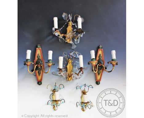 Two pairs of French style brass wall lights, one pair with two lights, the other pair with one light each, decorated with col
