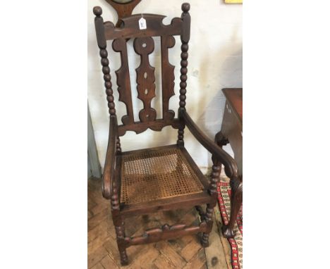 A pair of 17th century style stained beech Carolean hall chairs with caned seat below a pierced splat on bobbin turned legs, 