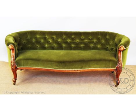 A Victorian carved walnut serpentine Chesterfield / conversation settee, with button back green upholstery, on scroll legs, b