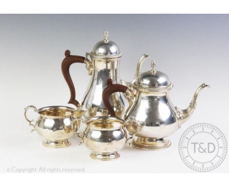 A George III style silver four piece tea and coffee service, Barker Ellis Silver Co, Birmingham 1972, with pineapple finials 