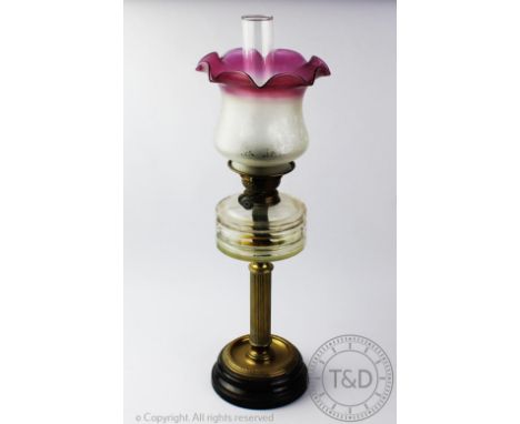 A late Victorian brass oil lamp, with etched shade with a faceted glass reservoir, on a fluted column and circular base, 61cm