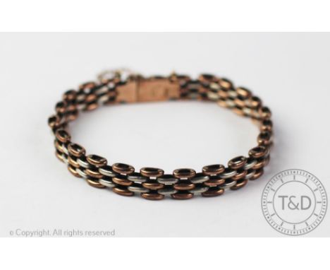 A bi-colour gold gate type bracelet, with integral clasp and safety chain, clasp stamped '9ct D&amp;F', weight 15.3gms CONDIT