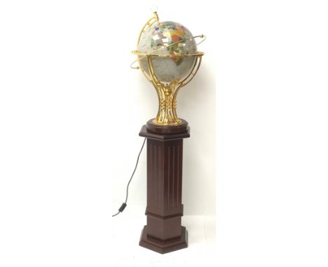 An electric operating rotating gem stone style globe with brass mount and wooden base, upon wooden hexagonal column stand.  -