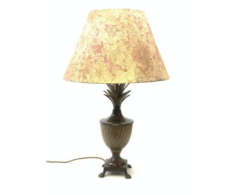 A cast metal table lamp, the base of square form with four pad feet leading to a spreading food, oblique detailed urn form bo
