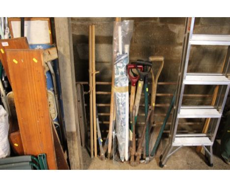 A quantity of tools including shears, bolt croppers, metal rake, wooden handled shovel and a parasol etc