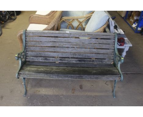 A two seater garden bench with green painted cast iron bench ends
