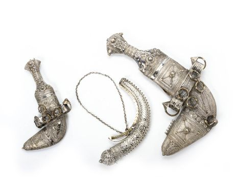 TWO MIDDLE EASTERN KHANJARS AND A POWDER FLASK With elaborate silver filigree decoration, the blade to the larger example det